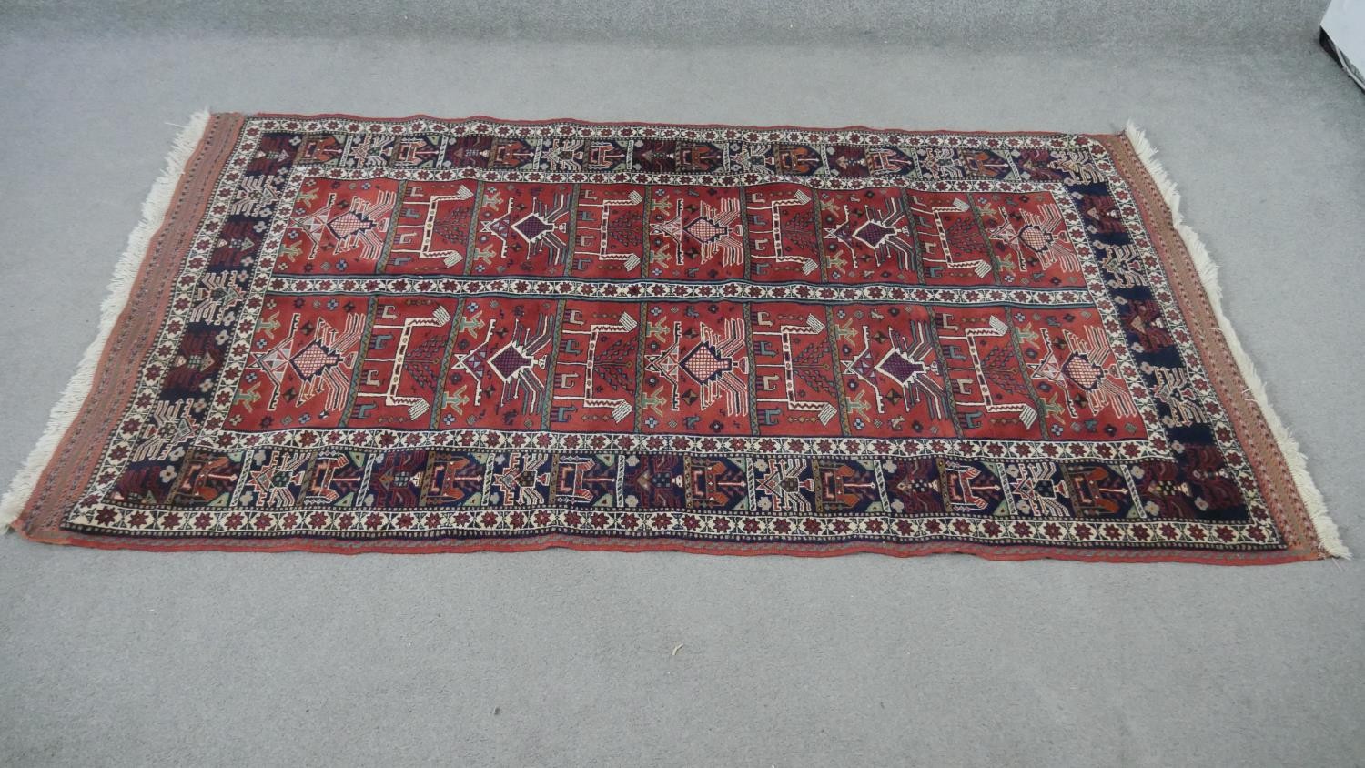 A Persian Kurdish rust ground hand made rug. L.200 W.115cm.