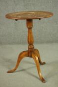 A 19th century oval tilt top tripod table, with a turned stem. H.70 W.52 D.37cm