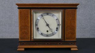 An Art Deco geometric marquetry design Elliot clock, brass movement and brushed chrome ring dial