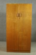 A mid 20th century E Gomme oak wardrobe with two doors, containing hanging space, drawers and