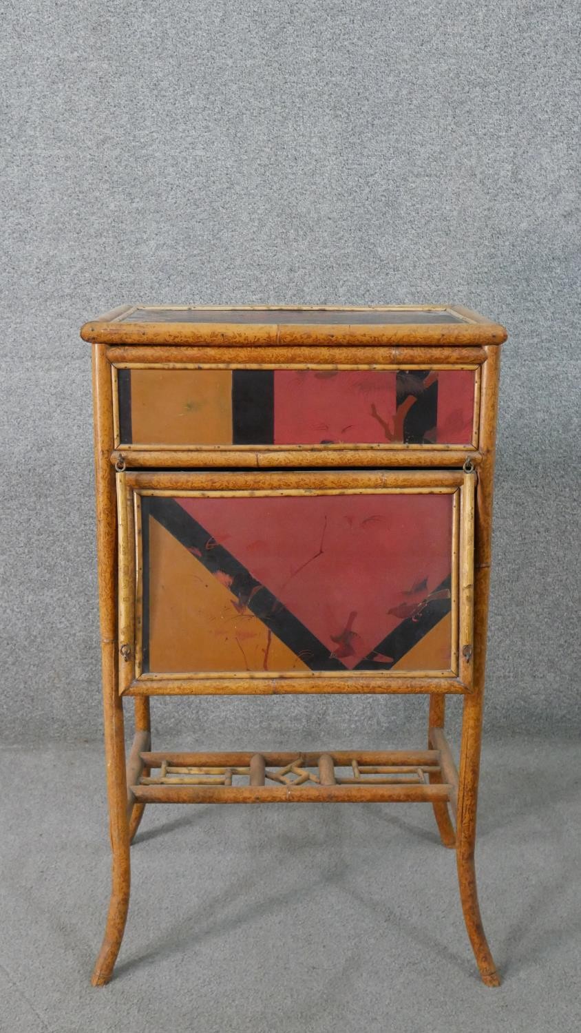 An Aesthetic Movement bamboo work table, with Japanese lacquered panels, the lid opening to reveal a