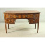 A George III style flame mahogany bowfronted kneehole desk, with a tooled brown leather skiver