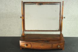 A George III mahogany toilet mirror, with a rectangular mirror plate over the bow fronted base