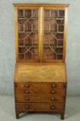 An early 19th century mahogany bureau bookcase, with a pair of astragal glazed doors, over a fall