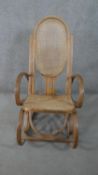 Manner of Michael Thonet, a bentwood rocking chair with a caned back and seat.