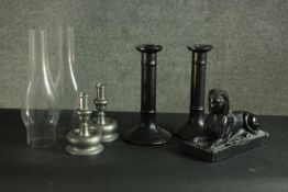 A pair of pewter candle sticks, a pair of black ceramic candle sticks, two funnels and a