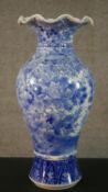 A large Japanese early 20th century blue and white hand painted porcelain vase with fluted edge.