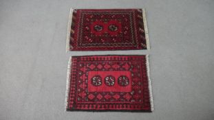 Two red ground Afghan rugs. H.72 W.50cm (Largest)
