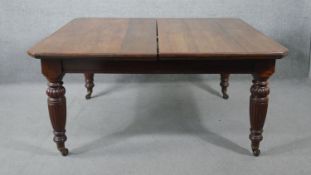 A Victorian mahogany extending dining table, the top with moulded edges, above a screw action; on