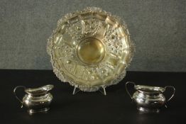 Three pieces of silver plate, including a milk jug and sugar bowl along with a repousse floral and