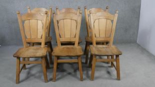 A set of six oak dining chairs, the shaped plank back, over a solid seat, on splayed square