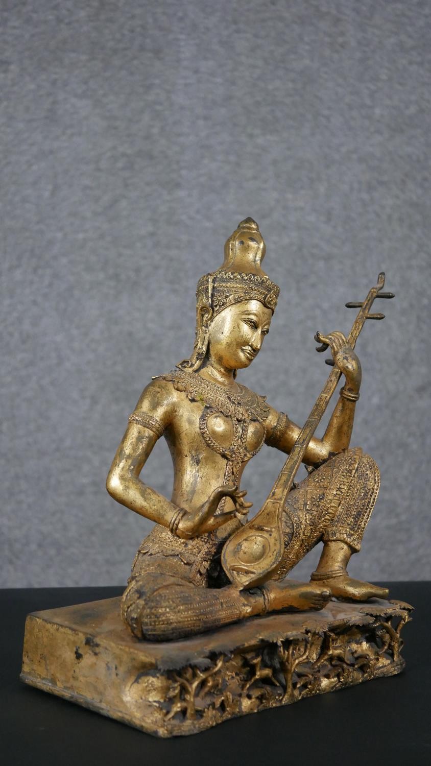 A 19th century gilded bronze Thai figure of Saraswati playing a vina. Animals and trees around the - Image 4 of 10