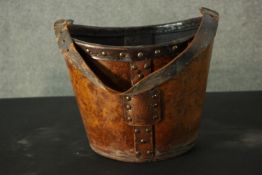 A studded brown leather bucket with carrying handle. H.28 W.37 D.31cm.