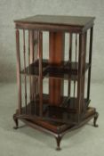 An early 20th century mahogany revolving bookcase, of square form, with two tiers and turned