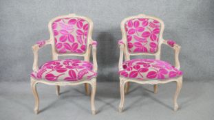 A pair of 20th century French Louis XV style fauteuil armchairs, with limed frames, upholstered in