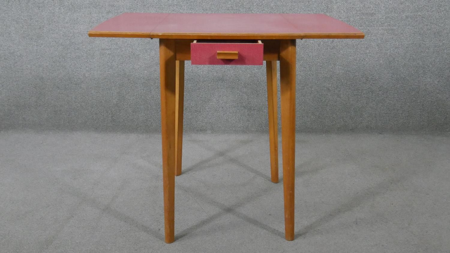 A 1950s drop leaf beech kitchen table, with a pink formica top and a single end drawer. H.78 W.47 - Image 2 of 5