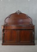 A Victorian walnut serpentine chiffonier, the rounded arch back with carved detail, over a long