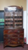 A George III mahogany secretaire bookcase, with a curved cornice over astragal glazed doors, the