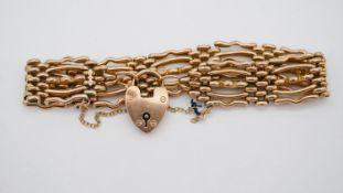 A Victorian yellow metal (tests as 9 carat gold) gate leg bracelet with heart shaped padlock clasp