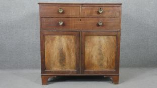 A George III mahogany linen press, with two short over one long graduated drawer, above two cupboard