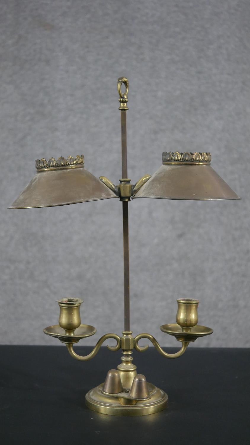 A 19th century brass double rise and fall student's candle lamp with scrolled arm supports. H.49 W.
