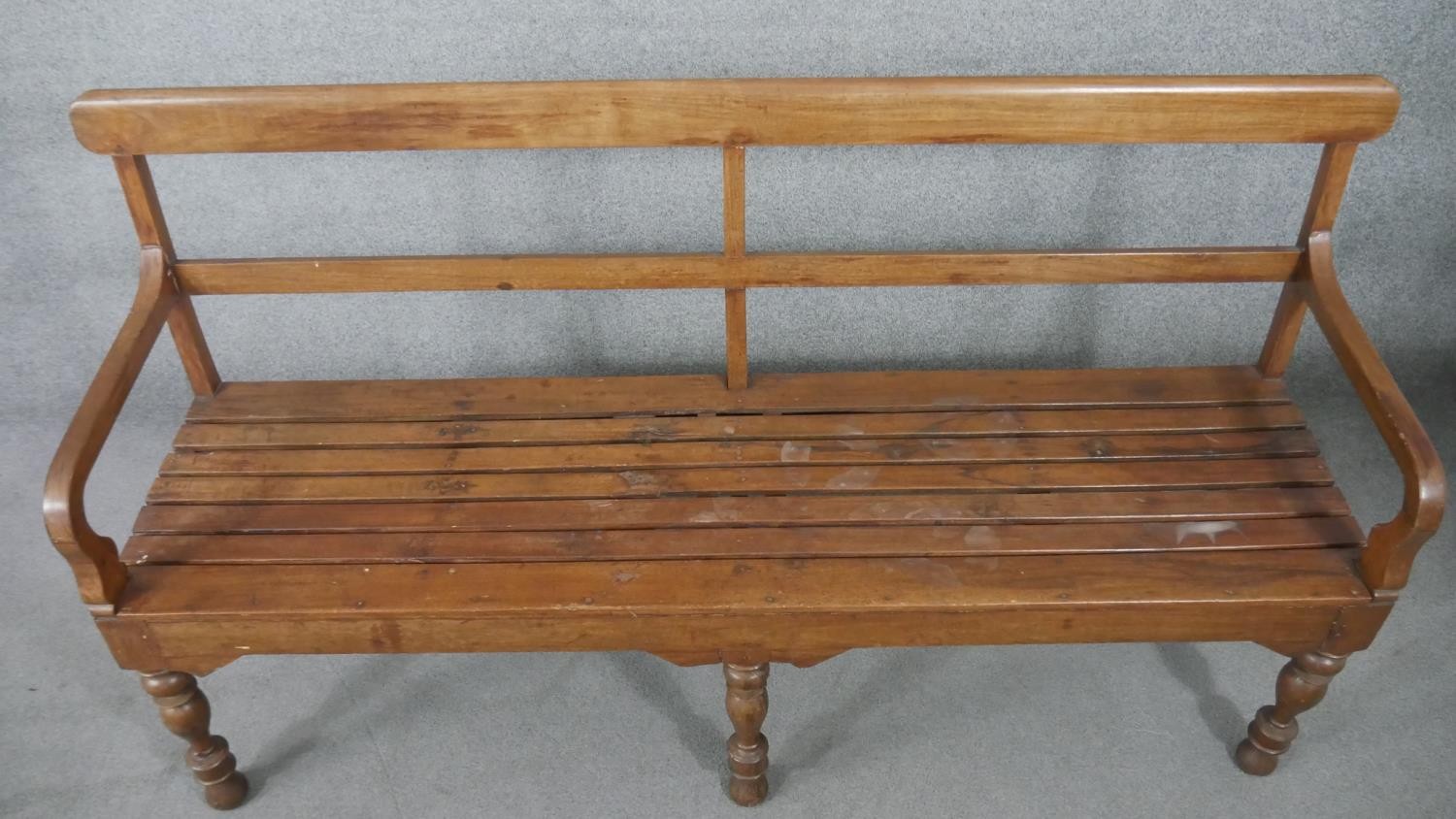 An Indian teak bench, with a bar back and open arms, over a slatted seat, on turned legs. H.93 W.165 - Image 2 of 6