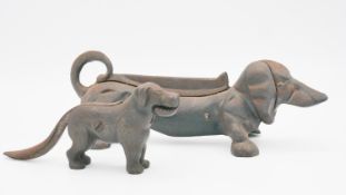A vintage style cast iron boot scraper in the form of a Dachshund and a similar nut cracker. H.12