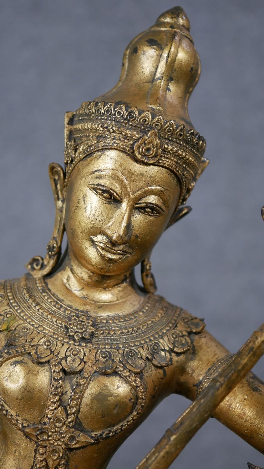 A 19th century gilded bronze Thai figure of Saraswati playing a vina. Animals and trees around the - Image 2 of 10