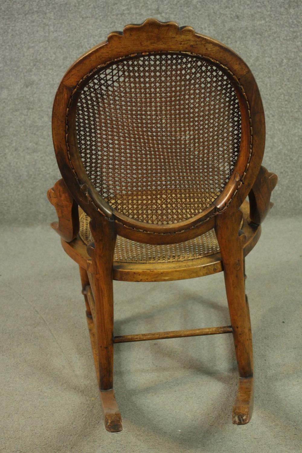 A fruitwood rocking chair, the oval back, and the seat both caned, on turned legs joined by - Image 4 of 6