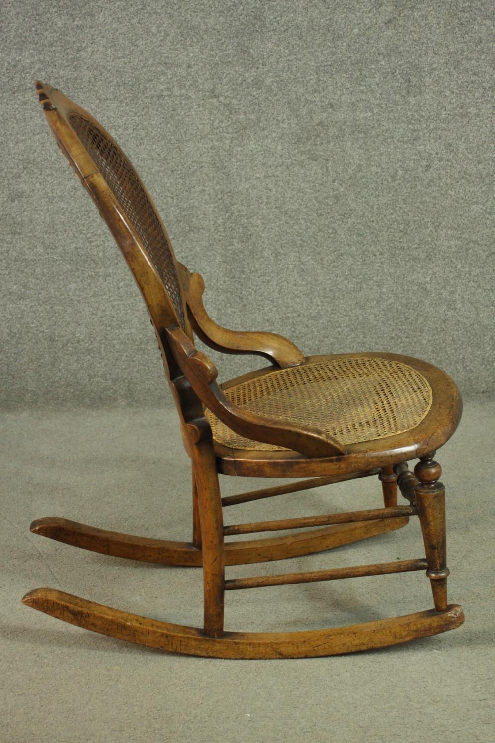 A fruitwood rocking chair, the oval back, and the seat both caned, on turned legs joined by - Image 3 of 6