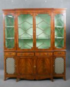 A George III style flame mahogany breakfront bookcase, with a dentil cornice over four astragal