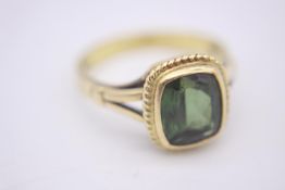 An 18 carat and green tourmaline dress ring. Set to centre with a rectangular mixed cut tourmaline