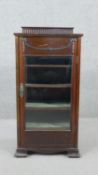 An Edwardian mahogany neoclassical revival music cabinet, with a fluted gallery back over applied