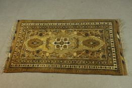 A gold ground hand made Afghan rug. L.140 W.92cm