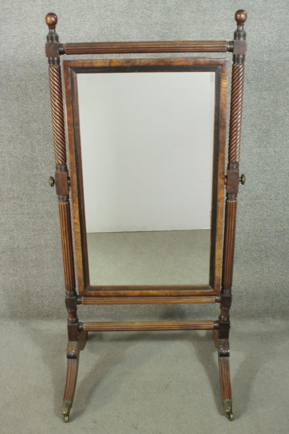 A George III mahogany cheval mirror, with a wrythen and reeded frame, set with a modern mirror