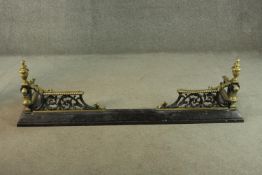 A 19th century iron and brass fire fender with pierced foliate design and urn finials. H.34 W.141