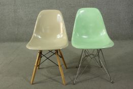 Two chairs designed by Charles and Ray Eames, with fibreglass seats, one mint green, the other