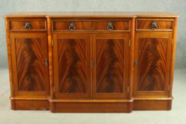 A Charles Barr George III style flame mahogany breakfront sideboard, with three short drawers,