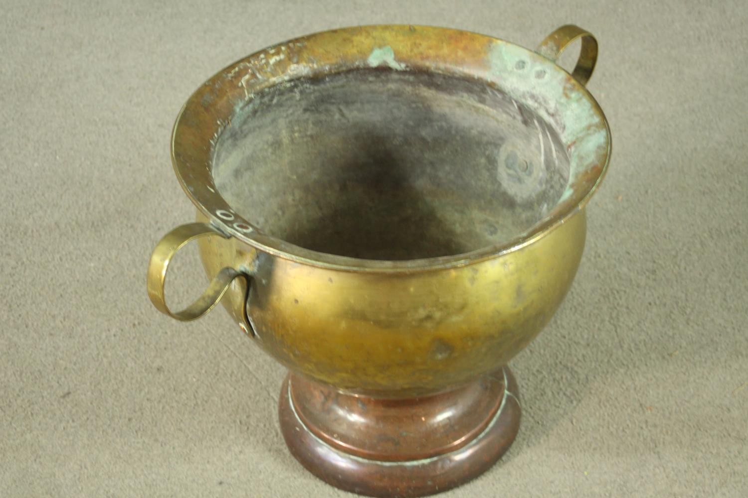 A 19th century twin handled brass pot on a copper circular stepped base. H.35 Dia.58cm. - Image 4 of 7
