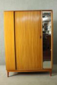 A mid 20th century teak Austin Suite wardrobe, with a single door, a mirror to one side, stamped, on