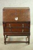 An early 20th century oak bureau, the fall front opening to reveal a fitted interior consisting of