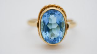 An 18 carat yellow gold blue stone (possibly blue zircon) dress ring, set with an oval cut stone