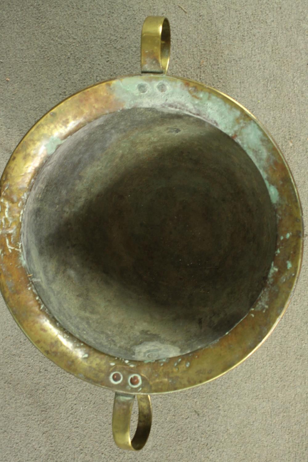 A 19th century twin handled brass pot on a copper circular stepped base. H.35 Dia.58cm. - Image 3 of 7