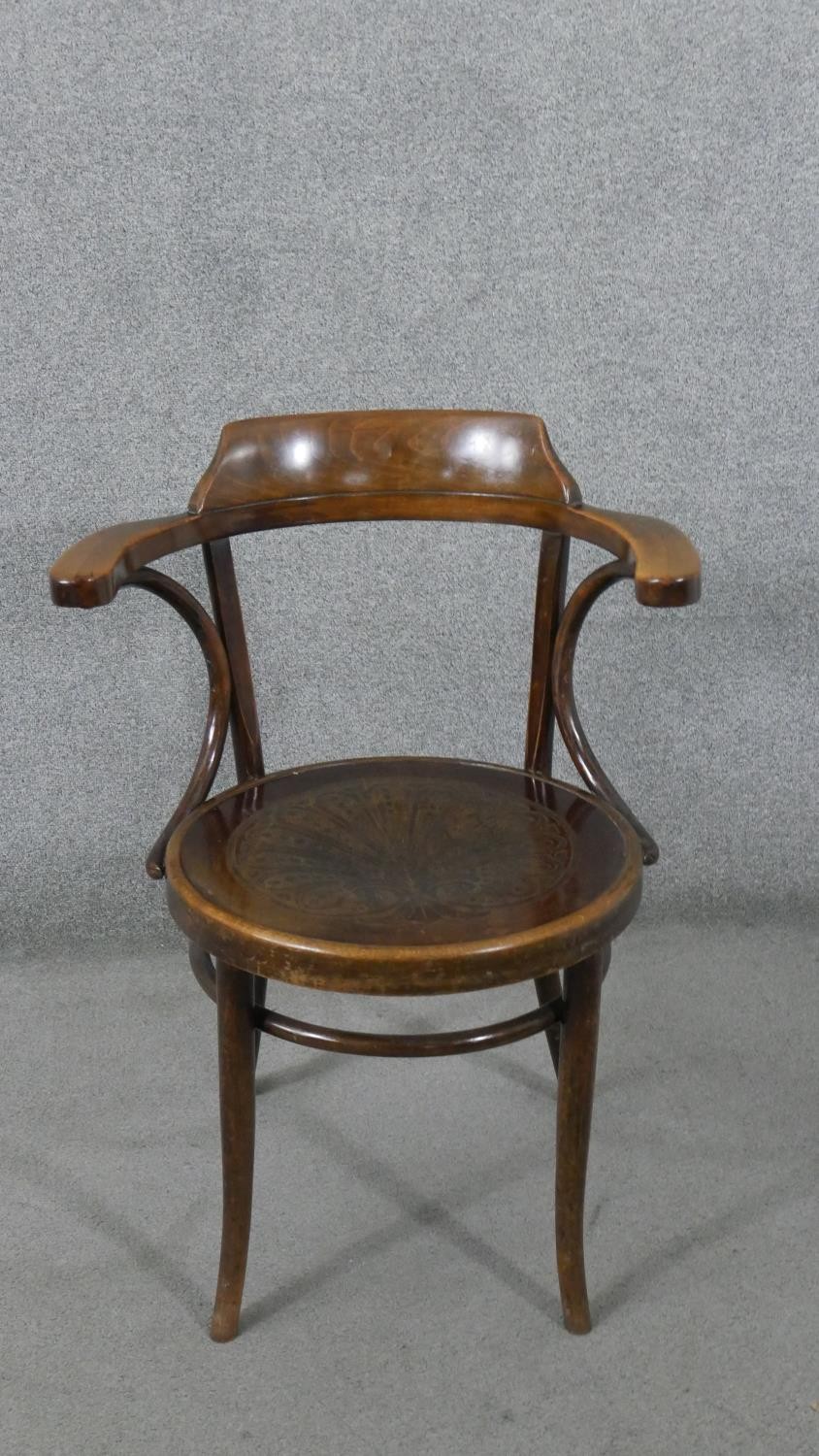 A late 19th/early 20th century Thonet style bentwood open armchair, with a circular pokerwork seat
