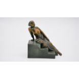 An Art Deco style patinated bronze of a woman reclining on steps. Unsigned. H.15 W.15 D.8cm