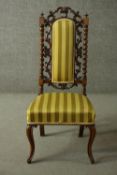 A Victorian walnut prie dieu chair, the back ornately carved and pierced with stiff leaf decoration,