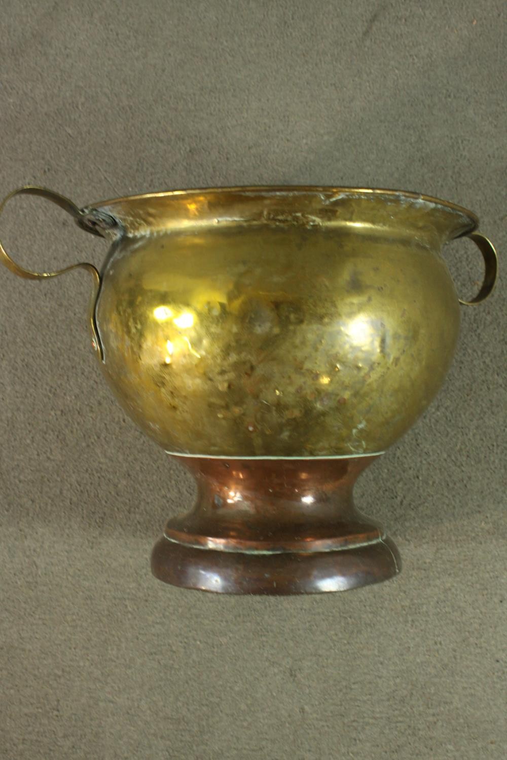 A 19th century twin handled brass pot on a copper circular stepped base. H.35 Dia.58cm. - Image 7 of 7