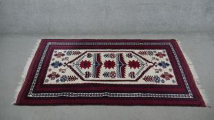 An Afghan Belouch rug, on a cream ground. L.190 W.110cm