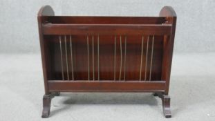 A circa 1960s teak magazine rack, the two sections with brass rods, on end feet. H.42 W.50 D.24cm