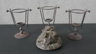 Three metal candle holders along with a carved stone figure of a hedgehog. H.16 W.30cm (hedgehog)